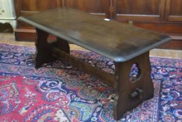 An Ercol style dark oak rectangular coffee table, raised on pierced shaped end supports (h.43cm x