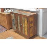 An Indian hardwood distressed finish side cabinet, fitted with a pair of panel doors flanked by