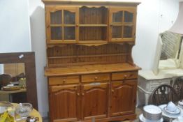 A modern pine two part kitchen dresser, with centre open shelf flanked by glazed panel doors,