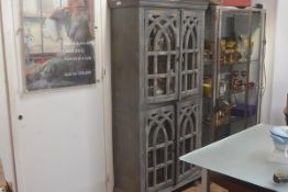 An Indian display cabinet with grey distressed painted finish, the moulded cornice above two pairs