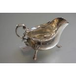 A Sheffield silver George III style scalloped sauceboat by Walker & Hall, raised on shell cast pad