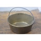 A large brass preserve pan with loop handle to top (h.10cm. d.45cm)