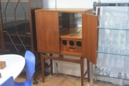 A 1970s teak cocktail cabinet, the rectangular top with moulded edge above a pair of arched panel