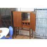 A 1970s teak cocktail cabinet, the rectangular top with moulded edge above a pair of arched panel