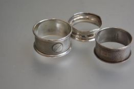 Three various Birmimgham silver napkin rings with engine turned and chased decoration (3)