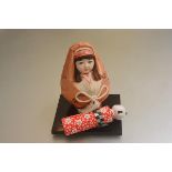 A Japanese Kokeshi style doll and a baby doll complete with hardwood stand (h.18cm and 16cm) (2)