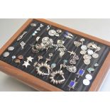 A showcase containing a collection of silver and white metal rings, earrings, bracelets, some with