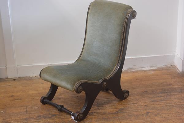 A 19thc ebonised brass mounted child's scroll back chair, upholstered in draylon, raised on scroll
