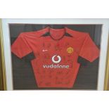 A Manchester United red and black shirt, signed by the complete team including David Beckham, c.