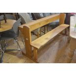 An oak church pew with shelf back, on shaped arched top side supports with plank seat (h.76cm x