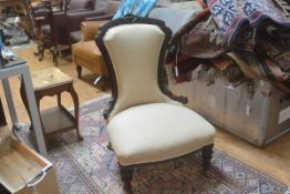 A Victorian mahogany nursing chair with carved moulded arched top, with upholstered panel back and