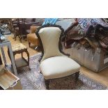 A Victorian mahogany nursing chair with carved moulded arched top, with upholstered panel back and