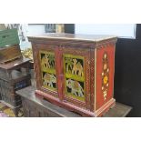 An Indian painted hardwood cabinet, the top with floral and leaf spray, with gilded border, above