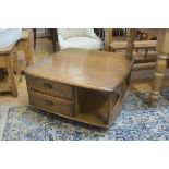 An Ercol elm coffee table, the shaped squared top with rounded angles and open sides, fitted two