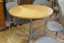 A modern circular oak veneered pedestal kitchen dining table on tubular centre column and