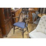 An American style walnut arched spindle back open armchair with upholstered stuffover seat, on