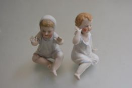 A pair of 19thc bisque Boy and Girl figures in night attire, decorated with polychrome enamels (