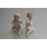 A pair of 19thc bisque Boy and Girl figures in night attire, decorated with polychrome enamels (