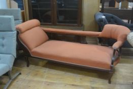 An Edwardian walnut scroll arm chaise longue style sofa with stuffover seat, raised on carved