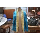 A Chinese gold and turquoise silk embroidered reversible short jacket with slash pockets to front (