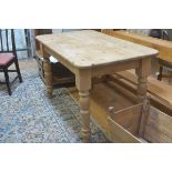 A 19thc style stripped pine kitchen dining table, the rectangular top with rounded angles and