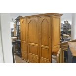 A French pine triple panel door armoire with moulded cornice, fitted three drawers, raised on plinth