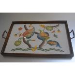 A 1920s oak glazed twin handled tea tray with hand embroidered running stitch pomegranate tree