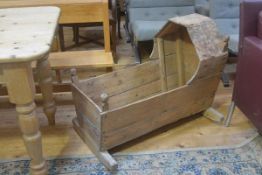 A 19thc pine cradle with arched top and shaped splay sides, complete with rockers, evidence of