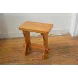 A pine stool, the rectangular top raised on shaped end supports united by stretcher (h.45mc x 41cm x