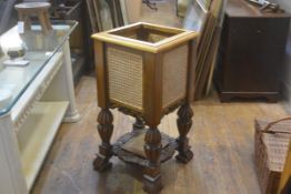 An Eastern hardwood cane double panel sided jardiniere stand with carved frieze, raised on fluted