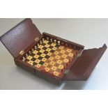 An Edwardian mahogany folding chessboard complete with carved bone chessmen (two missing) (h.6cm x