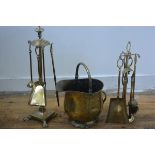 A four piece brass companion set on circular urn finial stand and paw feet, complete with brush etc.