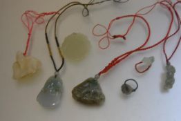 A group of modern jadeite pendants including a celadon jadeite lohan, a green jadeite carved