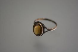 A yellow metal oval citrine mounted ring (S/T) (stone 1.5cm x 0.5cm)