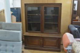 An Edwardian oak dwarf two part bookcase, the moulded cornice above a pair of glazed panel doors,