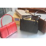 A lady's brown patent leather bag, a faux crocodile black leather two handled bag, a pink double