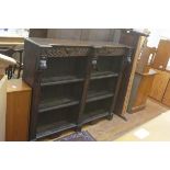 A Victorian oak upright open bookcase, the shaped top with relief carved urn and radiating frieze