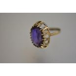 A 9ct gold ring mounted purple stone, in raised claw setting (J) (3.55g)