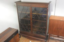 A late 19thc mahogany cabinet on stand, the moulded dentil cornice above a pair of glazed astragal