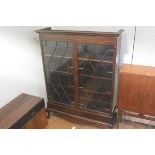 A late 19thc mahogany cabinet on stand, the moulded dentil cornice above a pair of glazed astragal