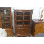 A Chinese elm and cherrywood display cabinet, the top with outswept edge, above a pair of glazed