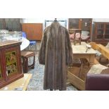 A lady's wild mink fur coat with leather loop belt, with slash pockets and satin lining (l. 110cm)