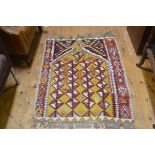 A flatwoven kelim prayer rug with pointed stepped arch enclosed within a stylised flowerhead border,
