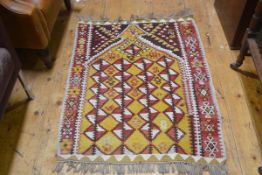 A flatwoven kelim prayer rug with pointed stepped arch enclosed within a stylised flowerhead border,