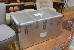 An aluminium bound cabin trunk with blue fablon lined check interior, with strap handles to side (