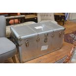 An aluminium bound cabin trunk with blue fablon lined check interior, with strap handles to side (