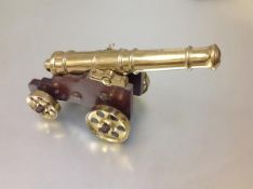 A bronze model cannon, the tapering multi-stage barrel with spherical cascabel on a mahogany