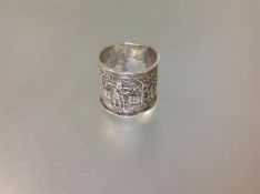 A Chinese white metal napkin ring, chased with figural and calligraphic panels, indistinct stamped