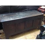 A late 17th/early 18th century oak four-panel coffer, the plain rectangular cover with moulded edge,