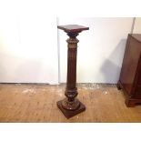 A gilt-metal mounted walnut columnar pedestal, the square top over a fluted column, on a baluster